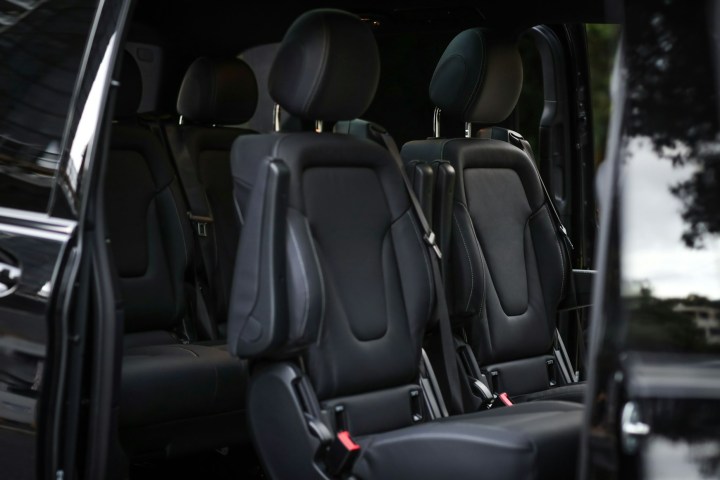 Interior of a vehicle showing three rows of black leather seats.