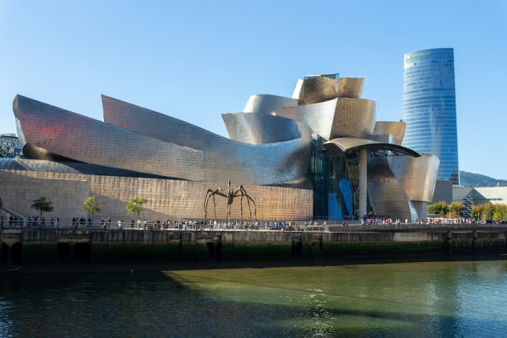 Guggenheim Museum Bilbao with a spider sculpture and river in foreground.