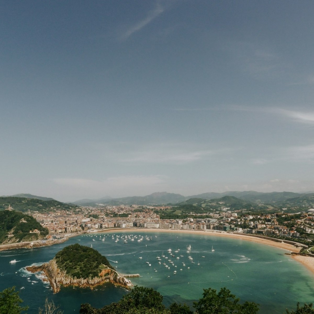Coastal city with beaches, small islands, and boats in the bay.